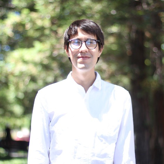 Person standing in white shirt and wearign glasses